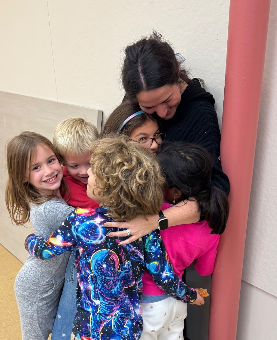 Sally Minkovich in a group hug with kids at the end of a BRICK Lab pilot session